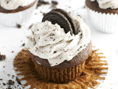 Chocolate Oreo cupcake with cookies and cream frosting topped with an Oreo cookie on a white background. Perfect for sweet tooth cravings and dessert ideas.