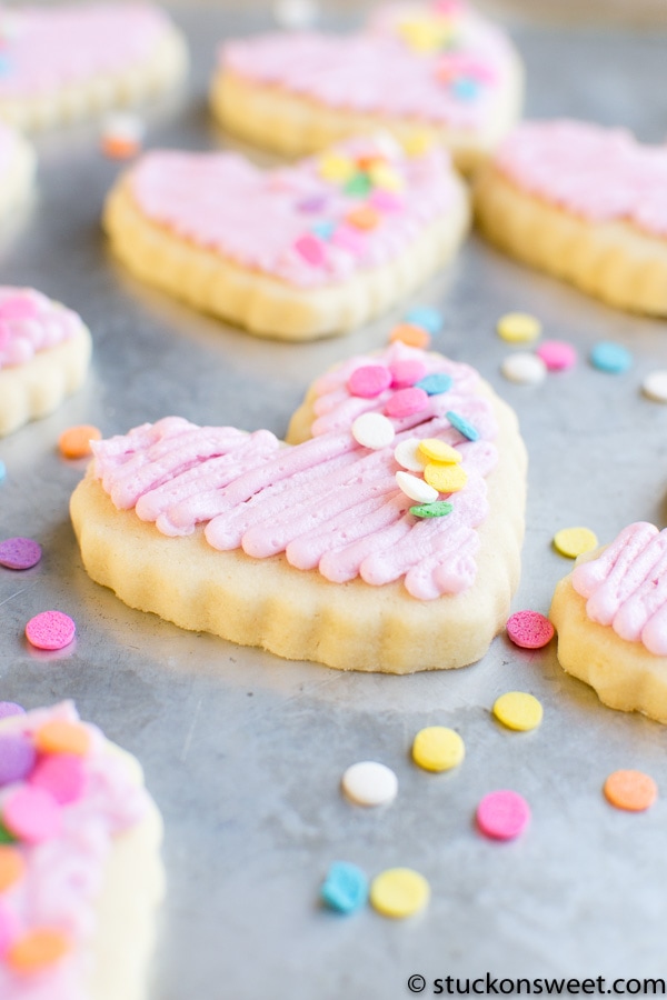 Heart-shaped sugar cookies with pink frosting and colorful sprinkles for Valentine's Day or special occasions. Perfect for sweet tooth cravings and cookie decorating ideas.