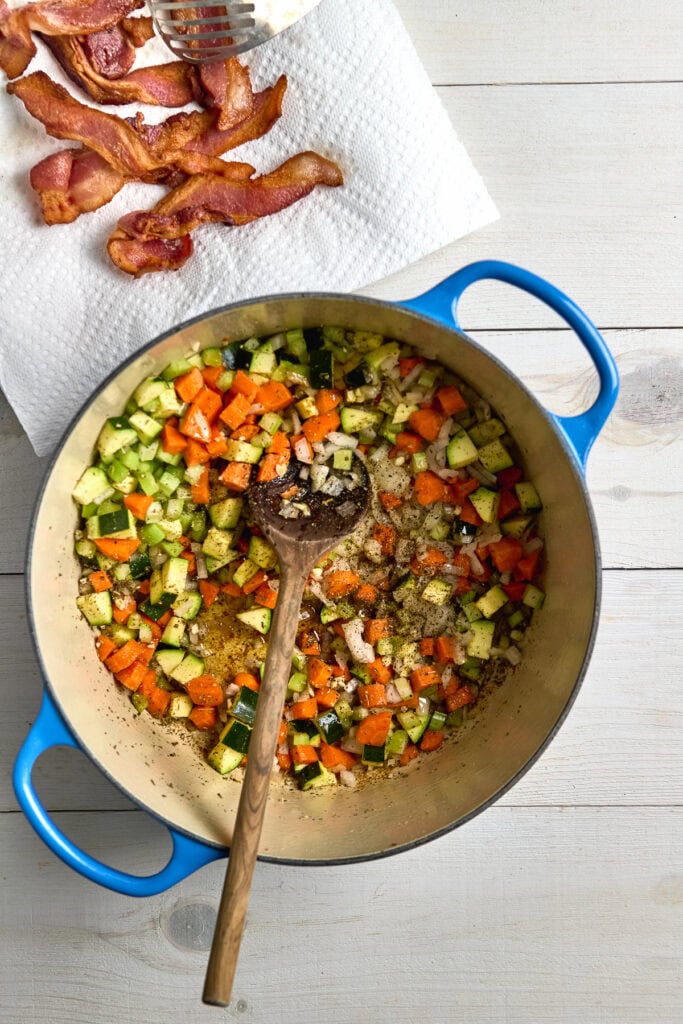 Sautéed vegetable medley with carrots, zucchini, and onions in a stovetop skillet for homemade meal preparation.