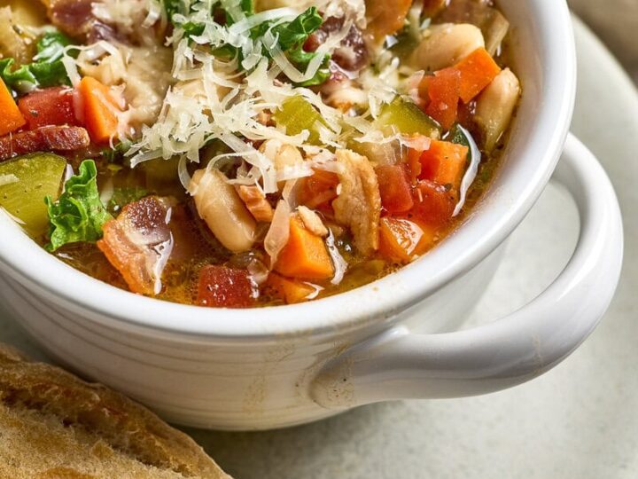 Tuscan Kale and White Bean Soup with shredded cheese, and fresh herbs served with fresh bread.