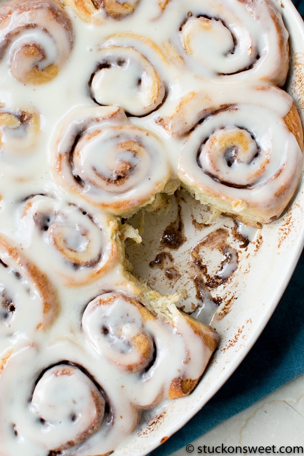 Cinnamon rolls with cream cheese glaze in a baking dish, freshly baked and topped with icing, perfect for breakfast or dessert.