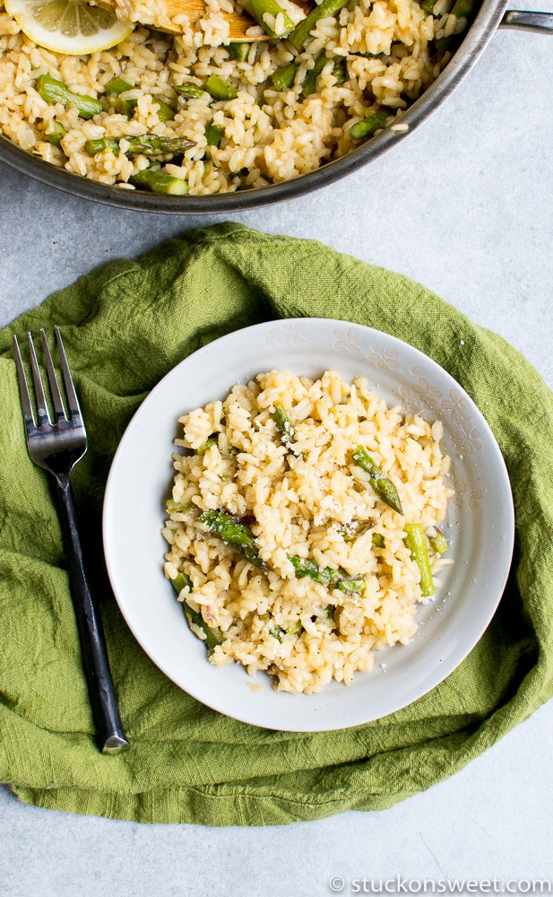 Savory rice pilaf with green beans and lemon slices on a white plate, served with a fork, green cloth napkin, and a pot of rice in the background. Perfect for healthy, flavorful meals.