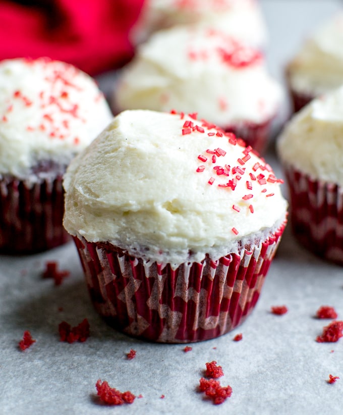 Creamy red velvet cupcake with vanilla frosting and red sprinkles, perfect for Valentine's Day or special occasions. Freshly baked, irresistibly sweet treat from Stuck On Sweet.