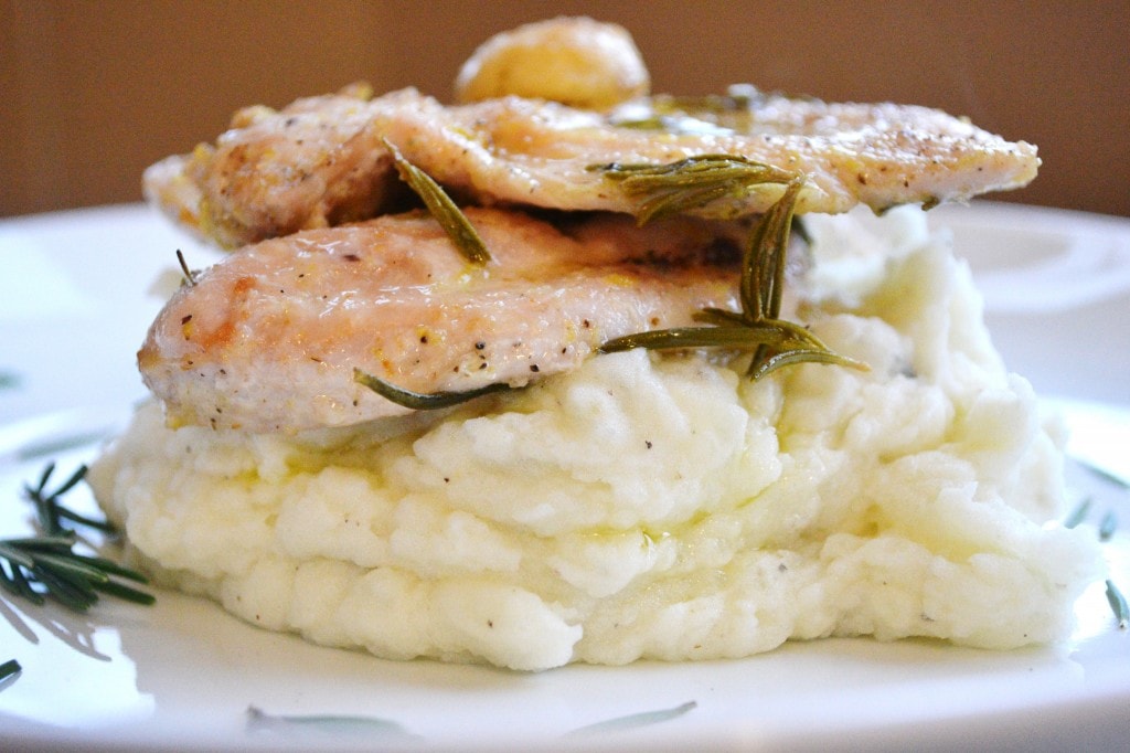 Juicy baked chicken thighs with herbs served over creamy mashed potatoes, garnished with fresh rosemary. Perfect comfort food recipe for a family dinner or special occasion.