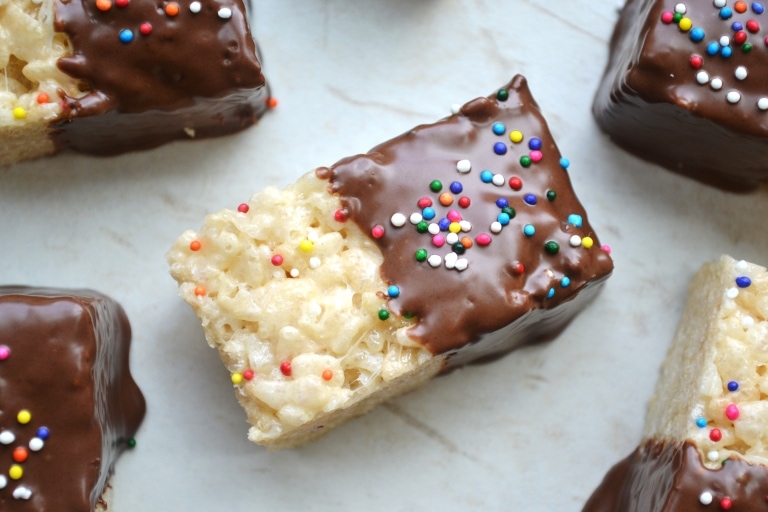Cheesecake bars topped with chocolate and colorful sprinkles, mid-century modern style. Perfect sweet treat for parties and celebrations. Delicious, creamy, and topped with fun rainbow sprinkles.