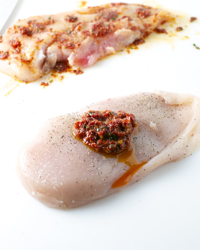 Sweet and savory stuffed chicken breast topped with spicy tomato sauce, served with a flavorful side dish, perfect for dinner.