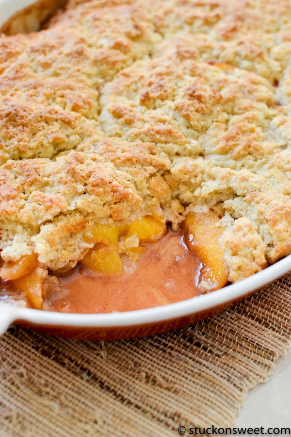 Rich peach cobbler with a golden, crumbly crust and bubbly, warm fruit filling in an oval baking dish. Perfect for comforting desserts or summer gatherings.