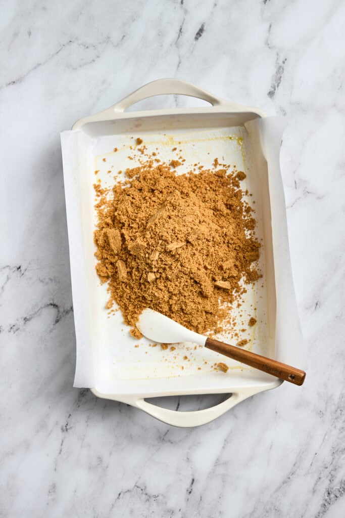 Crushed graham crackers in baking dish for dessert crust or topping.