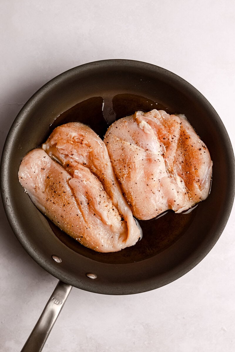 chicken breasts being sautéed in a pan 
