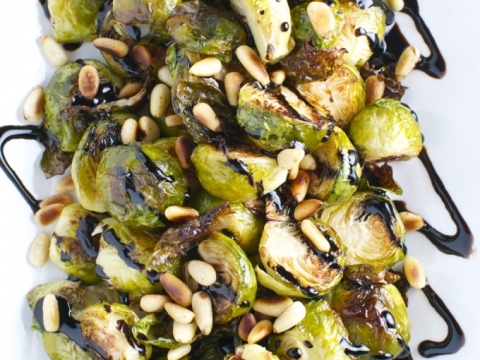 Roasted Brussels sprouts with balsamic glaze and toasted pine nuts, served as a delicious and healthy appetizer or side dish at Stuck On Sweet. Perfect for vegetable lovers and gourmet cuisine enthusiasts.
