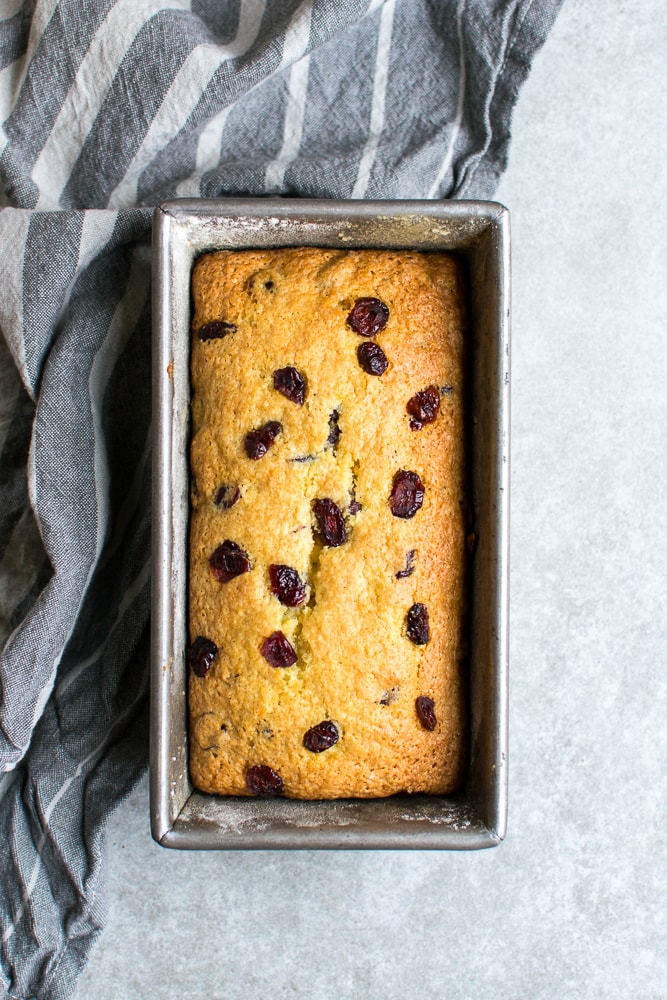 Delicious homemade cherry loaf cake in a metal baking pan. Perfect for dessert or tea time. Moist, flavorful, and loaded with cherries. A sweet treat from Stuck On Sweet.