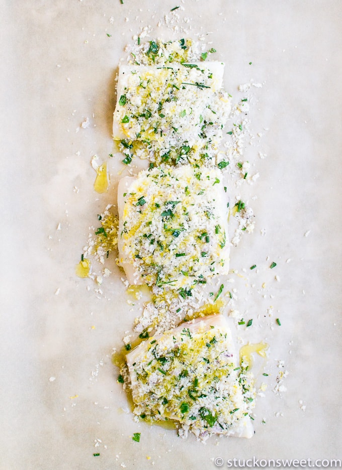 Fresh stuffed chicken breasts with lemon, herbs, and cheese on baking paper.