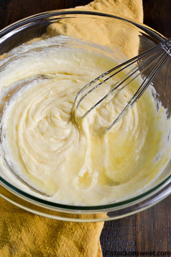Creamy vanilla cake batter in a glass mixing bowl with a whisk, ready for baking, perfect for homemade dessert recipes.