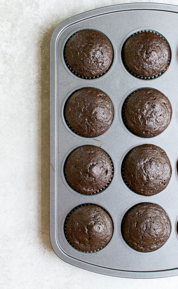 Rich chocolate cupcake muffins in a silver baking tray, fresh from the oven, perfect for a sweet treat or dessert.