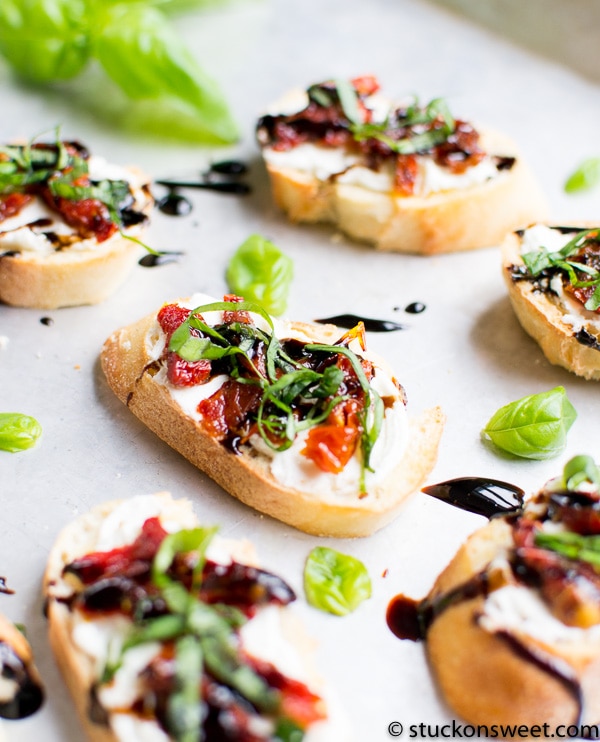 Fresh gourmet bruschetta topped with basil, sun-dried tomatoes, and balsamic glaze on toasted baguette slices. Perfect appetizer or snack, ideal for parties and gatherings.