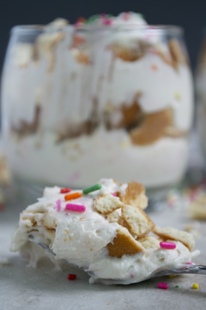 Creamy no-bake icebox cake with graham crackers, whipped cream, colorful sprinkles, and crushed cookies, perfect for sweet treats and desserts.