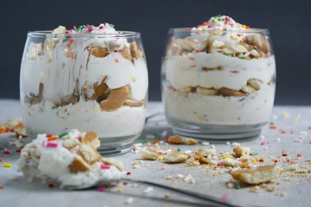 Sweet cookie and ice cream dessert served in glass cups with colorful sprinkles and broken cookie pieces.