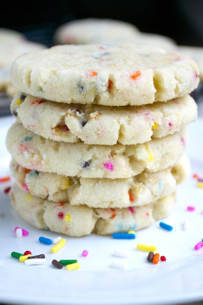 Buttered Sugar Cookie with colorful sprinkles stacked on a white plate.