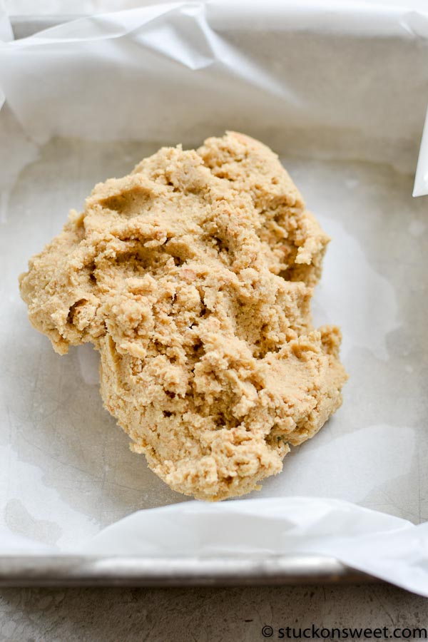 Creamy peanut butter cookie dough made with butter, sugar, peanut butter, eggs, vanilla, baking soda, and flour on a baking sheet. Perfect for homemade cookie baking.