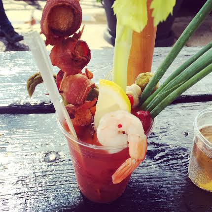 Fresh shrimp cocktail with lemon and vegetable garnishes served in a tall glass at Stuck On Sweet, perfect for seafood lovers and tropical-themed parties.