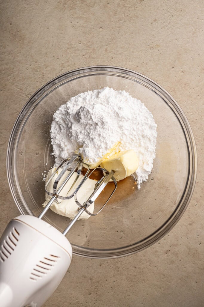 Flour, butter, vanilla, and cinnamon being mixed in a glass bowl for baking.