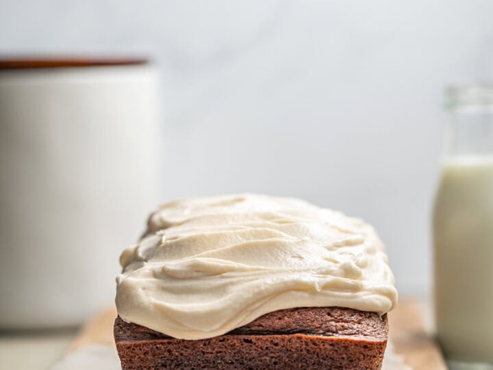 Moist chocolate loaf cake with creamy vanilla frosting on a wooden board, bakery dessert, homemade cake, sweet treat, Stuck On Sweet.