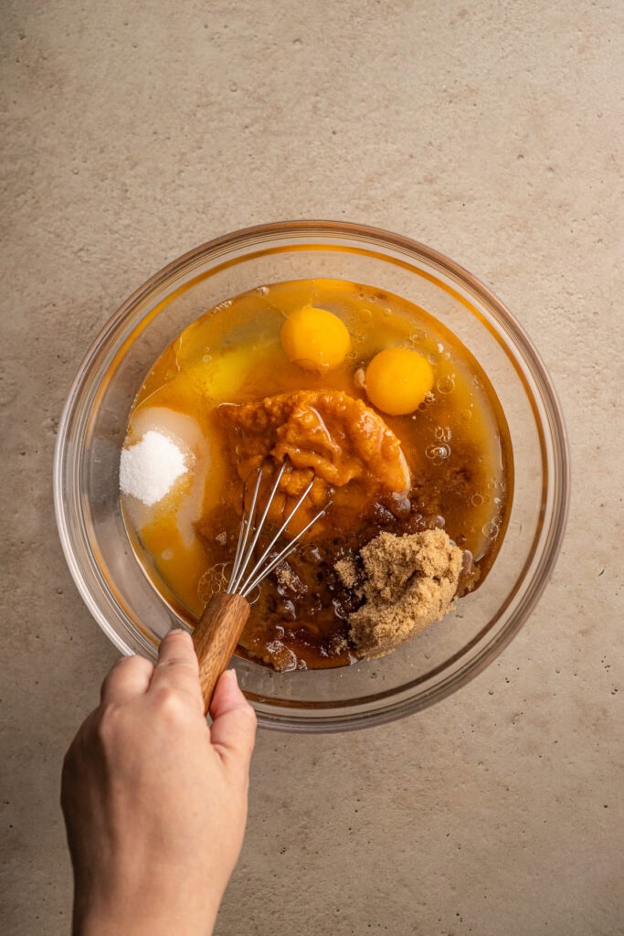 Cream, eggs, and sugar in a mixing bowl for baking or dessert making.