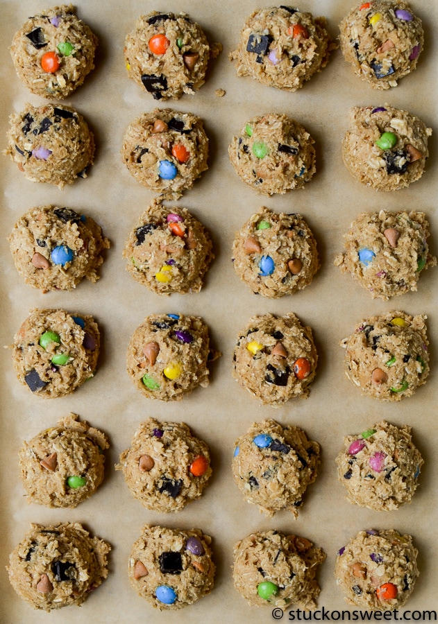 Chewy cookie dough balls with colorful chocolate chips and candies arranged on parchment paper, perfect for cookie dough lovers and dessert snacking.