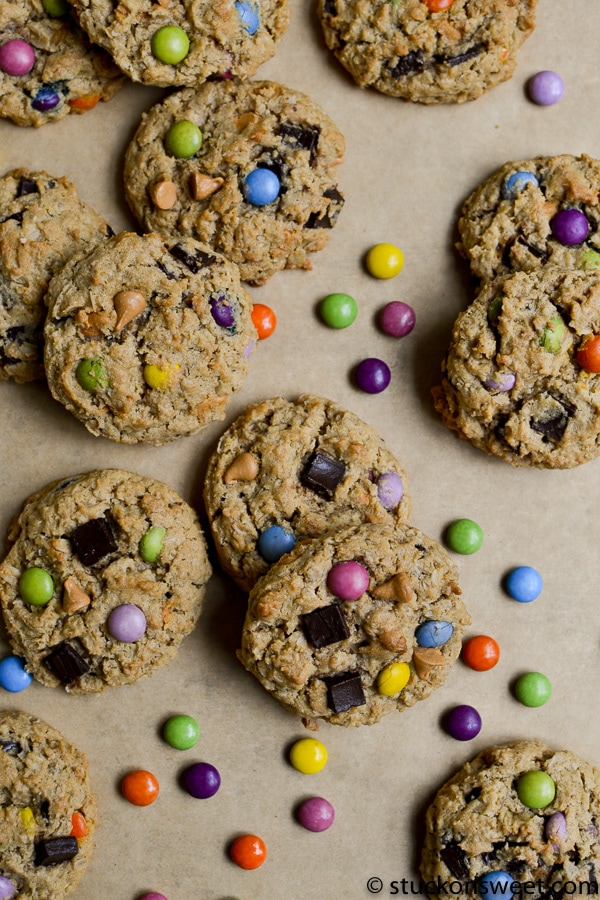 Colorful cookies with sprinkles and chocolate chunks on parchment paper.