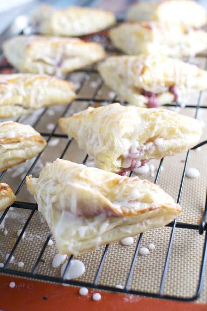 Buttery ham and cheese croissants with flaky layers and melty cheese, served on a cooling rack for a delicious breakfast or brunch.