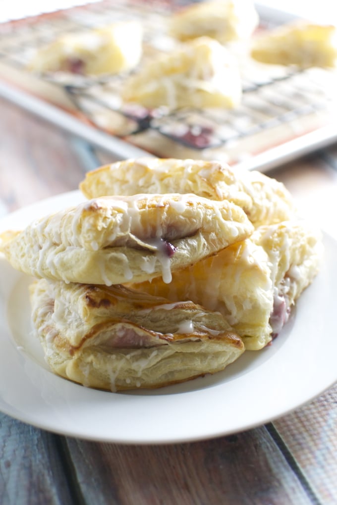 Flaky homemade cinnamon rolls drizzled with icing on a white plate, warm and inviting, perfect for breakfast or brunch.