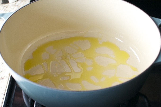 Butter melting in a blue cooking pot, close-up of melted butter.