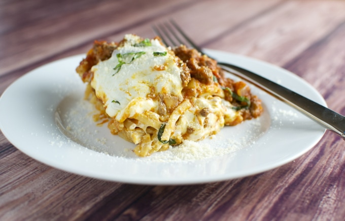 Creamy lasagna served on a white plate with melted cheese and fresh herbs, perfect for comfort food lovers and pasta enthusiasts.