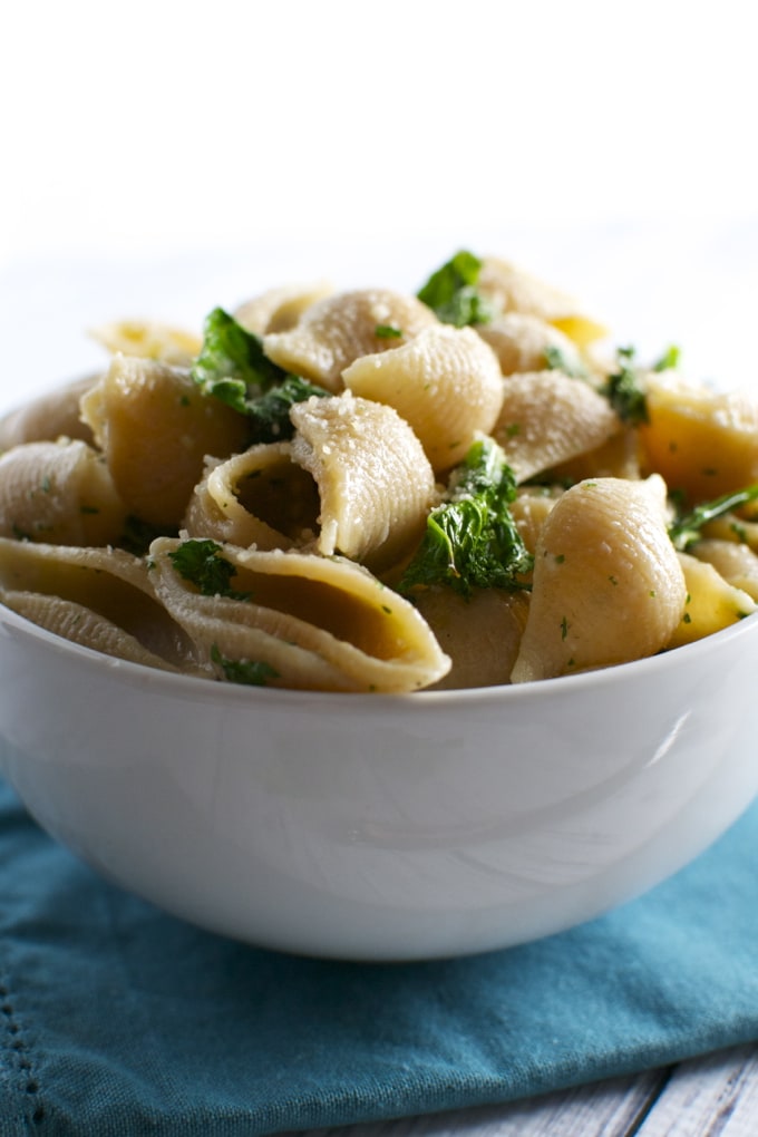 Creamy tortellini pasta with fresh herbs in a white bowl, perfect for comfort food or family dinners.