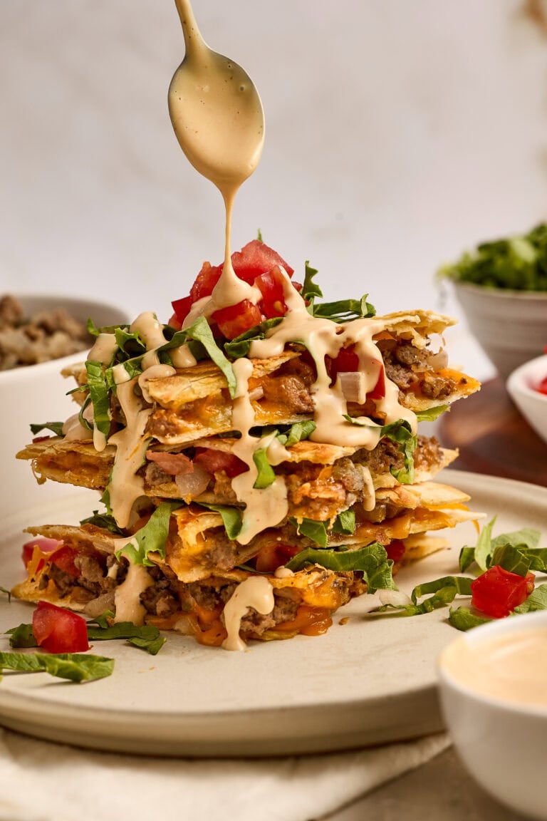Delicious cheeseburger quesadillas stacked high with melted cheese, fresh tomatoes, lettuce, and savory beef, perfect for a flavorful meal.