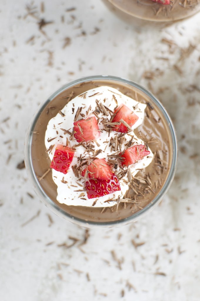 Creamy chocolate mousse topped with fresh strawberries, whipped cream, and chocolate shavings - perfect for dessert lovers.