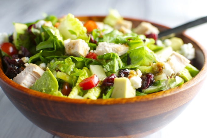 Fresh chicken Caesar salad with mixed greens, tomatoes, avocado, and blue cheese in a wooden bowl. Healthy, flavorful, and satisfying meal option from Stuck On Sweet.
