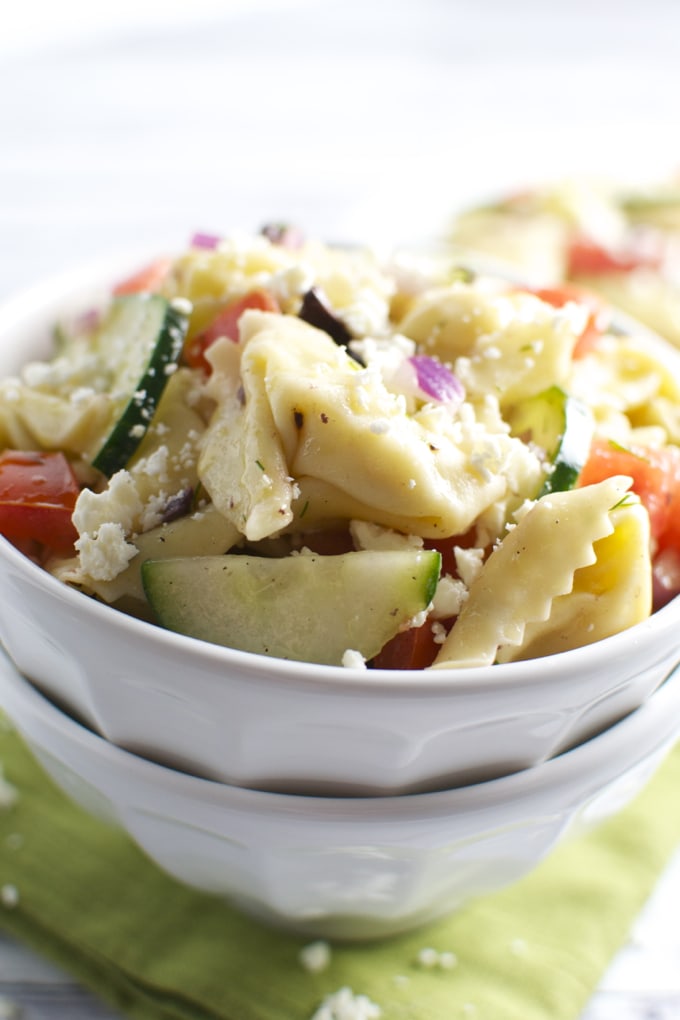 Creamy pasta salad with fresh cucumbers, tomatoes, and cheese, featuring bowtie pasta and vibrant vegetables, perfect for summer gatherings and outdoor picnics.