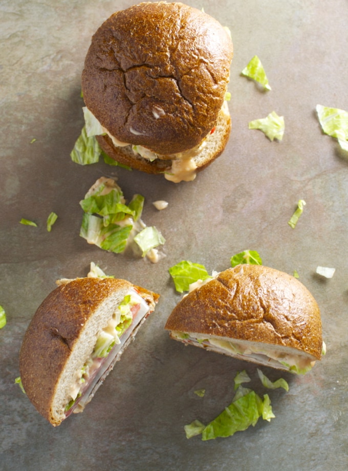 Crispy lettuce sandwich on whole grain bun with fresh lettuce and creamy filling, overhead view.