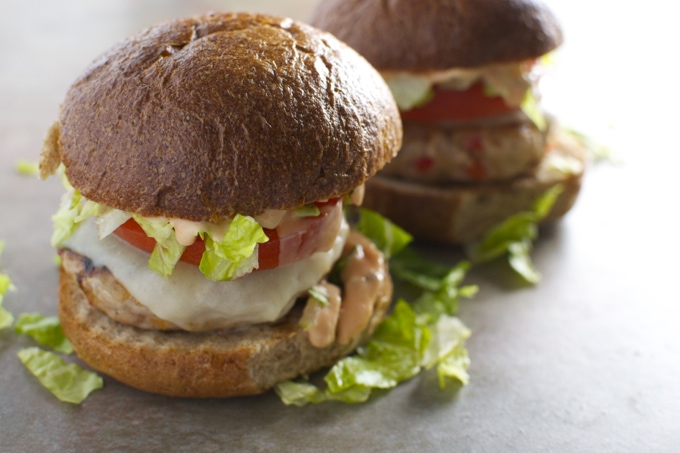 Fresh homemade lettuce and tomato burger on whole wheat bun, served with melted cheese and crispy lettuce. Perfect for a delicious, satisfying meal or snack.