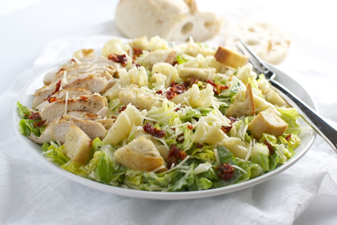 Fresh garden Caesar salad with grilled chicken, romaine lettuce, Parmesan cheese, croutons, and sun-dried tomatoes. Perfect for a healthy meal or lunch.