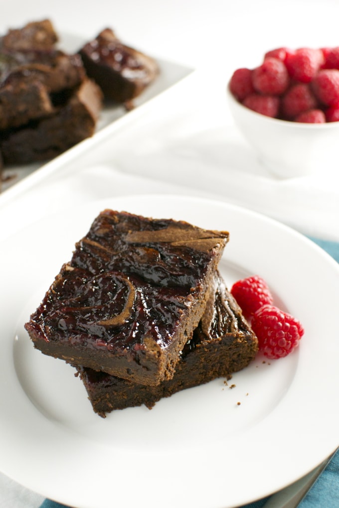 Rich, fudgy chocolate brownies with a glossy caramel topping served with fresh raspberries for a decadent dessert. Perfect for chocolate lovers and berry enthusiasts.