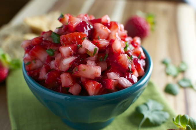 Fresh strawberry salsa in a blue bowl, perfect for dipping or topping dishes, made with ripe strawberries, herbs, and citrus. A colorful, healthy snack or appetizer from Stuck On Sweet.