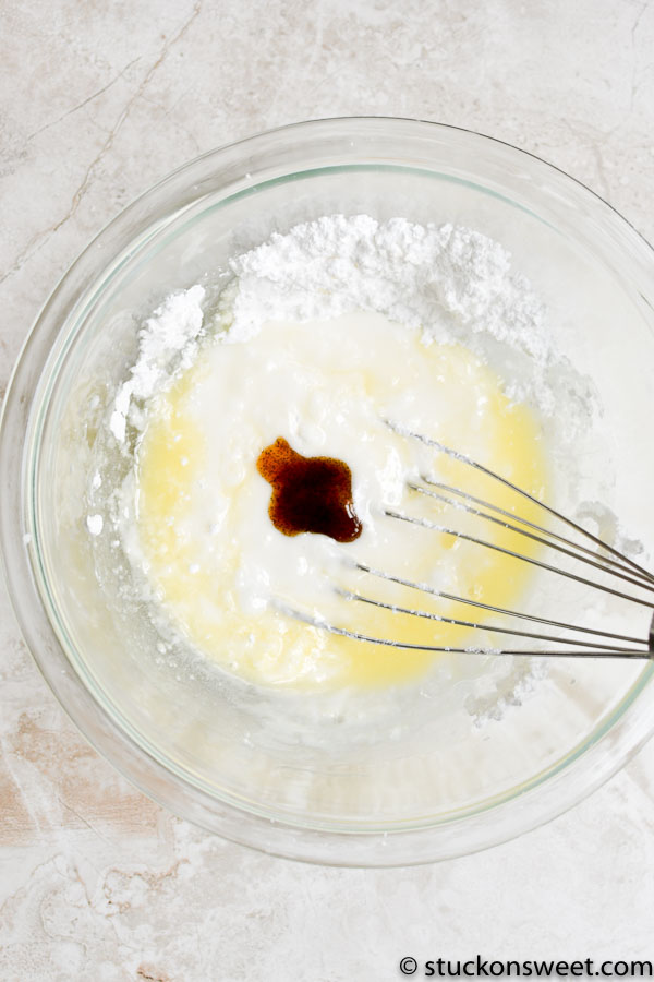 Buttermilk, vanilla, and caramel extract in a mixing bowl for cake batter preparation.