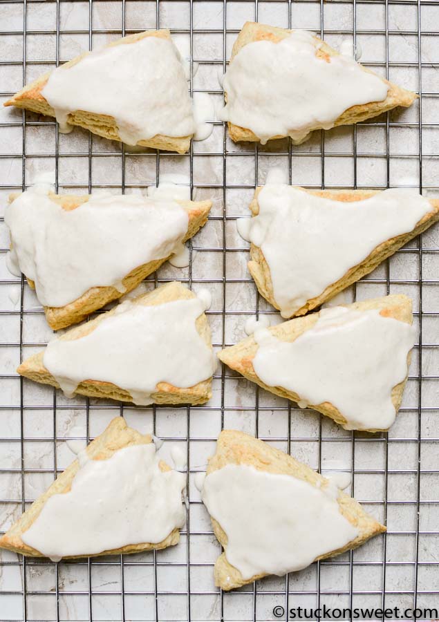 Sweet cinnamon sugar scones with glaze on a cooling rack, perfect for breakfast or tea time. Freshly baked, flaky, and topped with creamy icing, these homemade scones are a delightful treat.