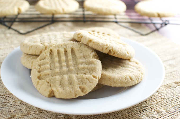 Butter cookies with a golden, crumbly texture on a white plate, freshly baked homemade shortbread cookies with textured fork marks, perfect for homemade cookie recipes or snack time.