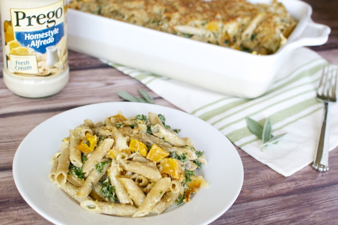 Creamy chicken and spinach pasta with roasted butternut squash on a white plate, delicious comfort food for family dinner.