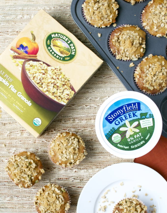 Natural peanut butter granola with oats and honey on a wooden surface with muffins and Greek yogurt. Healthy snack or breakfast options featuring organic ingredients.