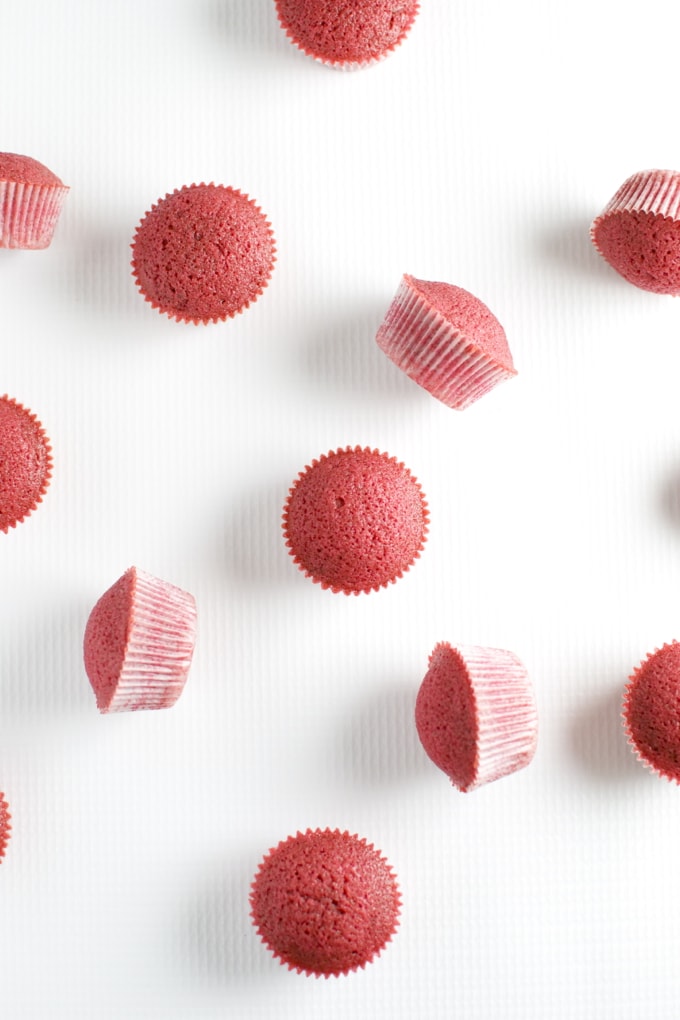Bright pink cupcake toppers and mini cupcakes with textured icing on a white background, perfect for cake decorations and baking supplies.