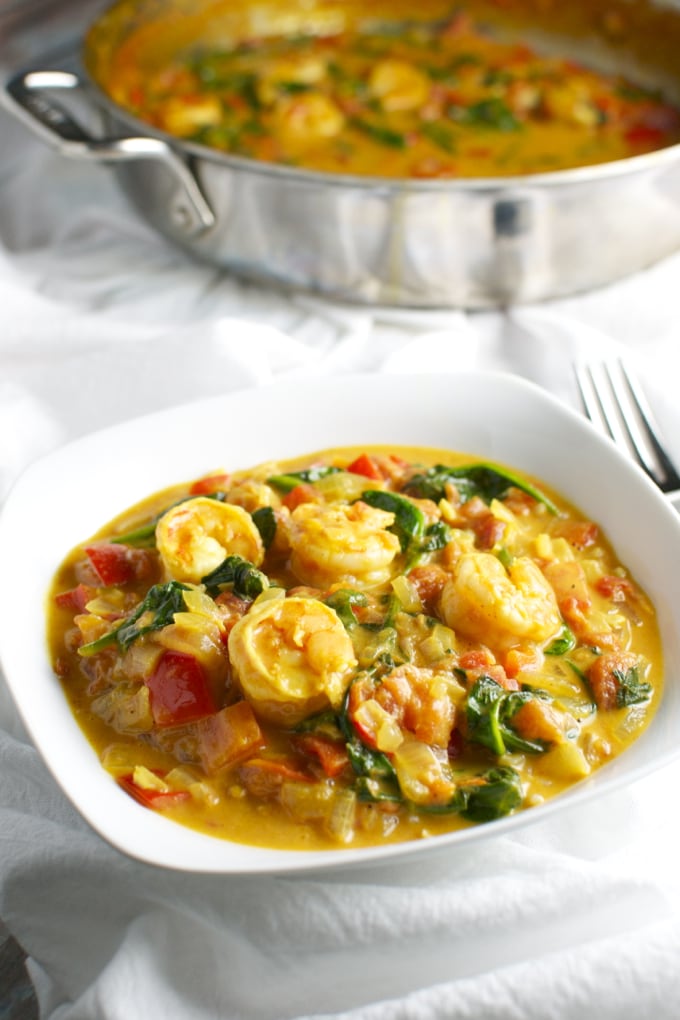 Creamy shrimp and vegetable curry served in a white bowl with a vibrant, flavorful sauce filled with shrimp, bell peppers, spinach, and spices. Perfect for a quick and delicious meal.